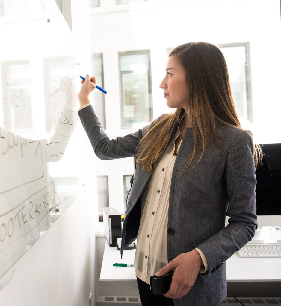 Eine Frau schreibt an ein Whiteboard